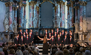 The ӣֱapp College Glee Club performs during its 2023 tour of the Baltics at St. Catherine's Church in Vilnius, Lithuania. Kammer is in the top row, third from left.  (Photo by Andrew Day)